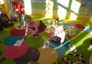 Dwie dziewczynki segregują odpady przedstawione na obrazkach do odpowiednich koszy.